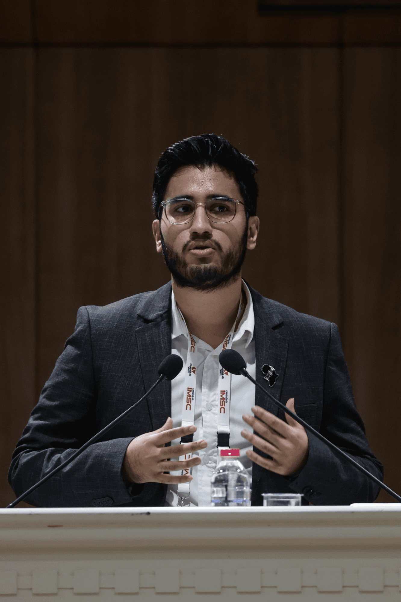 Waheed speaking at a podium at the Cansağlığı International Medical Student Conference in Istanbul